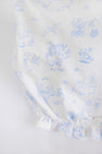 Experience the charm of The Beaufort Bonnet Company’s Sir Proper’s Sweet Arrival (Beale Street Blue) Bundle, featuring white fabric adorned with light blue illustrations of animals riding bikes, flying with balloons, and playing near trees and water. This adorable everyday set includes a layette gown with a ruffled edge at the bottom—making it a delightful baby shower gift. The bundle also comes complete with the lovable Bradley Bear for an extra special touch.
