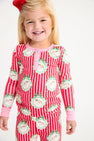 A young girl wears a Payton Pajama Set - Distinguished Doggies with Hamptons Hot Pink long-sleeved top and pants featuring a red and pink stripe pattern with dog illustrations inside decorative frames.