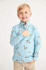 A smiling young boy with blond hair wears The Beaufort Bonnet Company’s “Pendleton’s Popped Collar - Fine Weather For Ducks with Grantley Gray” polo shirt, paired with khaki pants, standing against a plain white background.