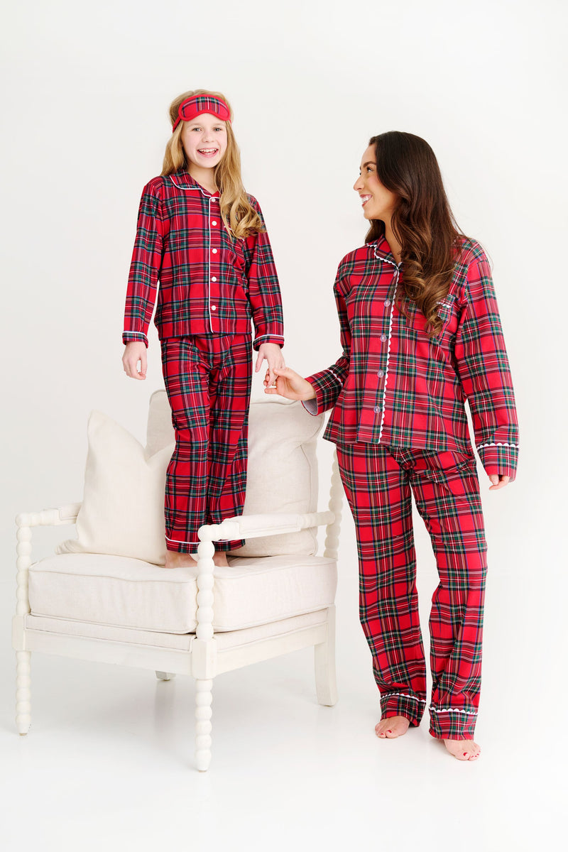 A girl standing on a chair and a woman standing beside her, both wearing matching Lock’s Little Set - Society Prep Plaid with Worth Avenue White holiday pajamas.