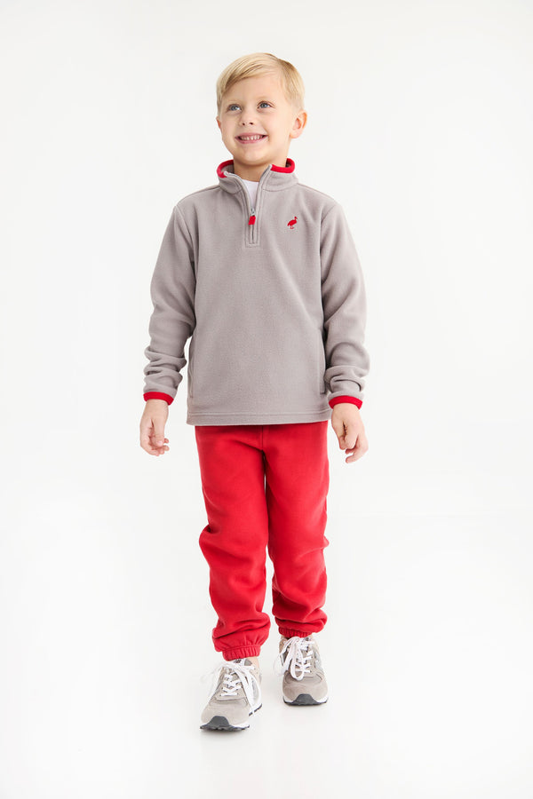 A young boy wears a cozy grey quarter-zip fleece pullover with red trim and matching Gates Sweeney Sweatpants - Richmond Red with Nantucket Navy Stork.