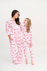 A woman and a young girl smile at each other while wearing matching Sara Jane’s Sweet Dream Set - Bonnie Scot Bows with Hamptons Hot Pink Pima cotton bow print pajamas.