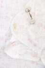 A silver rattle rests on The Beaufort Bonnet Company’s Sir Proper’s Sweet Arrival (Hamptons Hot Pink) Baby Buggy Blanket, made from pima cotton with pink animal and nature prints, ruffled edges, and a yellow label stitched in the corner.