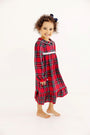 A young girl smiling while wearing a Goldie Locks Nightgown - Society Prep Plaid with Worth Avenue White in red, green, and white with a white collar and trim.