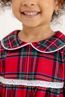 A smiling child wears a Goldie Locks Nightgown - Society Prep Plaid with Worth Avenue White, featuring a white-trimmed Peter Pan collar and white lace trim at the waist.