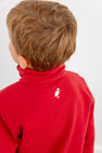 A young child with light brown hair wears The Beaufort Bonnet Company’s USC Hayword Half-Zip in South Carolina Burgundy with Worth Avenue White, featuring a white bird logo near the collar on the back that showcases classic Gamecock style. The child is turned slightly to the side, facing away from the camera.