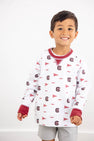 A smiling young boy stands in front of a plain white background, showing off his South Carolina Spirit in The Beaufort Bonnet Company’s USC Cassidy Comfy Crewneck—featuring white fabric with South Carolina Burgundy details and University of South Carolina logos and flags.