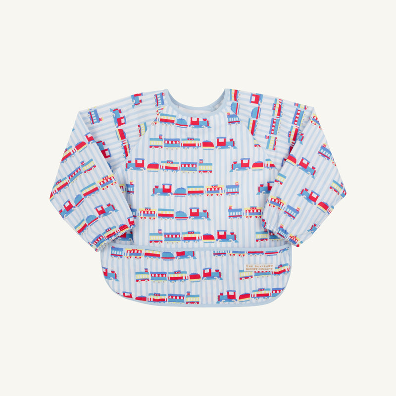 The Beaufort Bonnet Company’s Biscuit Bib - Choo Choo Coming Through with Buckhead Blue features a vibrant train motif and the playful phrase “Choo Choo Coming Through” on a light blue and white striped background, perfect for young children.