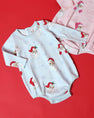 Two Long Sleeve Patton Play Bubble - Dear Santa (Buckhead Blue Stripe) rompers featuring a Santa Claus and snowflake pattern, one in blue stripes and one in pink stripes, against a red background.