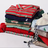A neatly folded stack of The Beaufort Bonnet Company’s Long Sleeve Prim & Proper Polos & Onesie in Richmond Red, Kiawah Kelly Green, and Palmetto Pearl Stripe is displayed on a white background.