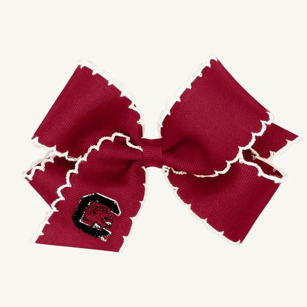The Wee Ones Hair Bow - University of South Carolina by The Beaufort Bonnet Company features garnet fabric with white scalloped edges and an embroidered red C logo on one loop, displayed against a plain white background.
