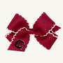 The Wee Ones Hair Bow - University of South Carolina by The Beaufort Bonnet Company features garnet fabric with white scalloped edges and an embroidered red C logo on one loop, displayed against a plain white background.