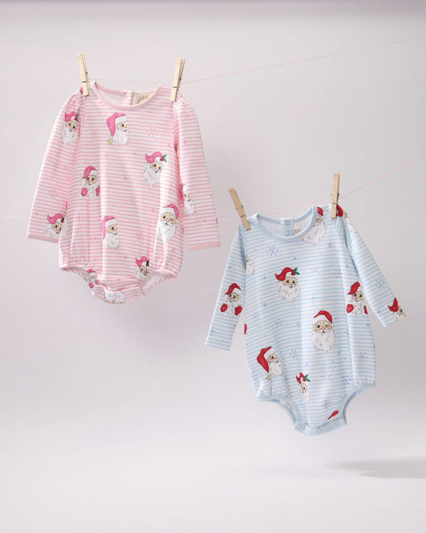 Two Long Sleeve Penny’s Play Bubble - Dear Santa (Palm Beach Pink Stripe) baby rompers with a Santa Claus and snowflake print hanging from a clothesline, one in pink stripes and one in blue stripes.