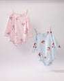 Two Long Sleeve Penny’s Play Bubble - Dear Santa (Palm Beach Pink Stripe) baby rompers with a Santa Claus and snowflake print hanging from a clothesline, one in pink stripes and one in blue stripes.