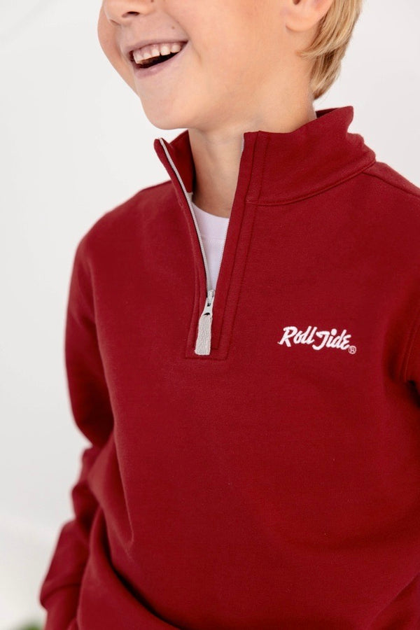Smiling child wearing The Beaufort Bonnet Company’s Alabama Hayword Half-Zip in Alabama Crimson with Alabama Grey and Worth Avenue White, perfect for game day layering, with only the lower half of the face visible against a plain light background.