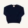 Isabelle’s Sweater in Nantucket Navy is a long-sleeved cotton sweater for girls featuring three brass-colored buttons on the left shoulder.