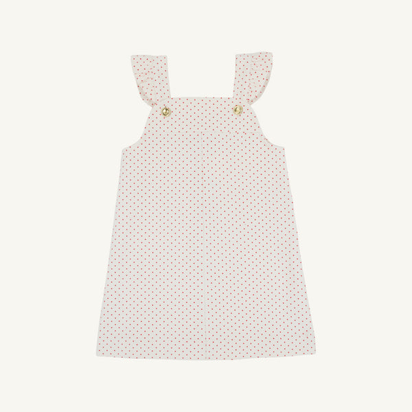 The Julia Jumper by The Beaufort Bonnet Company, shown laid flat on a white background, is a sleeveless pink corduroy dress featuring Richmond Red and Palmetto Pearl microdot polka dots, ruffled shoulder straps, and button details at the front.