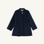 The Penelope Peacoat - Nantucket Navy by The Beaufort Bonnet Company is a girls’ peacoat with long sleeves, a single gold button at the collar, and a flared skirt. This simple and elegant design is displayed on a plain white background.