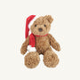 The Holiday Teddy Bear - Mon Ami by The Beaufort Bonnet Company, dressed in a red and white Santa hat with a coordinating scarf, sits against a plain white background—perfect as a festive holiday gift or cheerful seasonal decor.