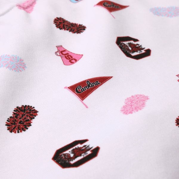 The Beaufort Bonnet Company’s USC Searcy Skort - South Carolina Spirit with Worth Avenue White features crisp white Pima cotton fabric adorned with playful red and pink pom-pom prints, pennants that say “Carolina,” a megaphone marked “USC,” and Gamecock mascot logos—a spirited celebration of South Carolina pride.