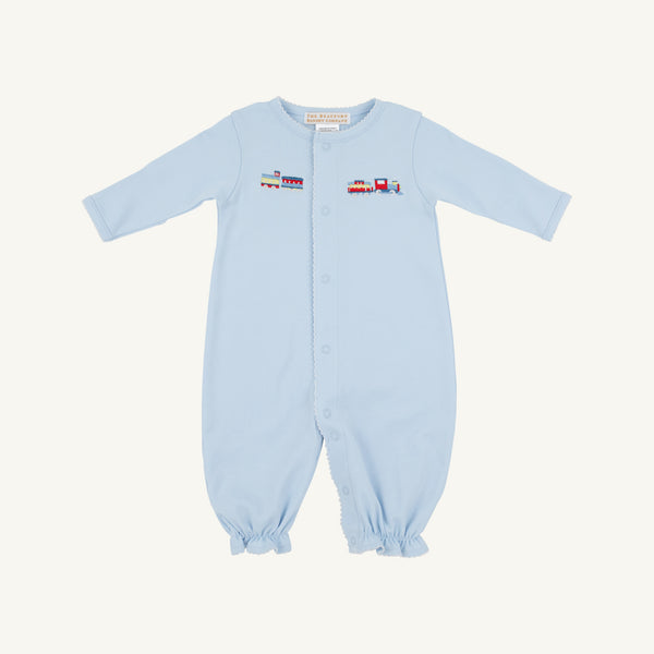 The Beaufort Bonnet Company’s Twinkle Twinkle 2-in-1 in Buckhead Blue with Trains is a light blue Pima cotton romper featuring long sleeves and legs, easy front snaps, and a vibrant embroidered train with colorful cargo cars across the chest. Gently gathered cuffs at the sleeves and ankles add to its soft, comfortable look.