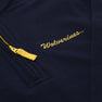 A close-up of The Beaufort Bonnet Company’s Michigan Hayword Half-Zip in Michigan Blue with a Michigan Yellow zipper, featuring “Wolverines” embroidered in yellow script above the pocket.