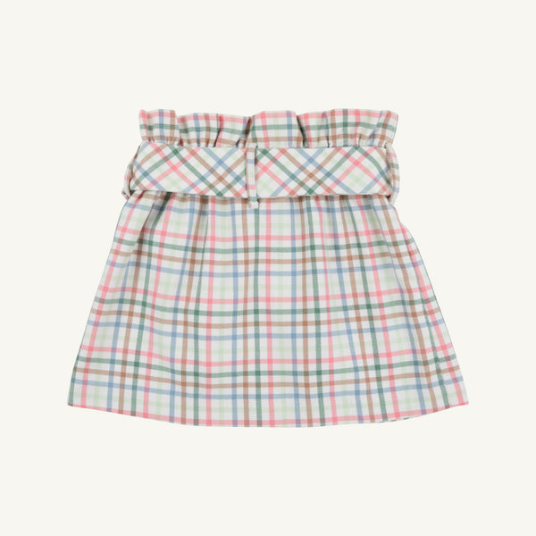 The Beasley Bow Skirt - Manalapan Plaid by The Beaufort Bonnet Company is a pastel plaid skirt featuring a gathered, ruffled waistband and a wide matching belt. Showcasing the signature Manalapan Plaid pattern for a light, summery look, this piece is presented on a plain, off-white background.