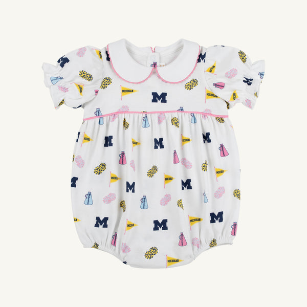 Dress your little one in The Beaufort Bonnet Company’s Michigan Britt Bubble – Bold in Blue with Hamptons Hot Pink. This white baby romper features charming puff sleeves, a Peter Pan collar, and pink trim. The playful pattern showcases blue M logos, yellow flags, blue and pink pom-poms, and megaphones. Made from soft Pima Cotton Knit with a gathered waist, it’s perfect for young fans who love to be bold in blue!.