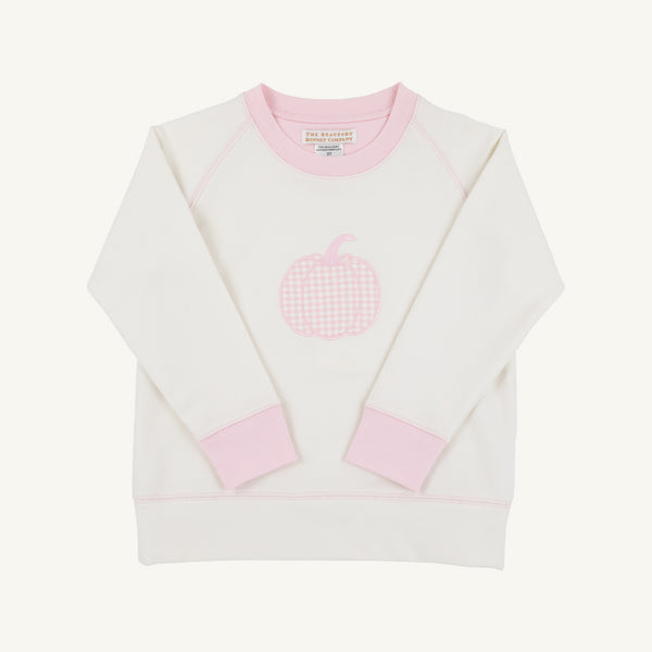 The Cassidy Comfy Crewneck by The Beaufort Bonnet Company is shown laid flat on a plain white background. This cozy sweatshirt features a Palmetto Pearl body with Palm Beach Pink accents on the cuffs, collar, and hem, and is adorned with a pink gingham pumpkin applique on the chest.