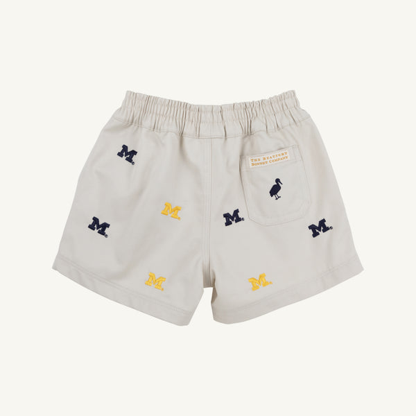 The Beaufort Bonnet Company’s Michigan Critter Sheffield Shorts in Saratoga Stone feature an elastic waistband, embroidered blue and yellow Michigan logos, and a small back pocket with a label and bird icon. These shorts combine comfort and school spirit for any fan.