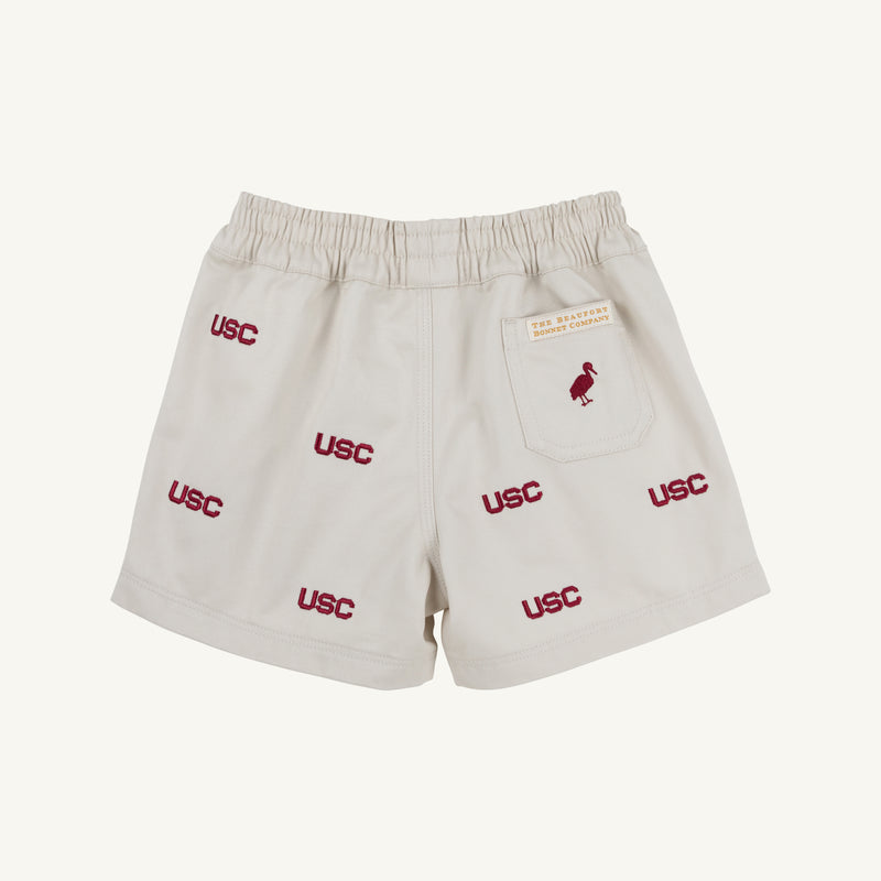 Show your Gamecock pride with the South Carolina Critter Sheffield Shorts in Saratoga Stone by The Beaufort Bonnet Company. These beige shorts feature an elastic waistband, multiple embroidered USC logos in red, and a small red bird on the back pocket—making them stadium-ready and perfect for true fans.