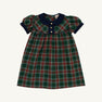 The Dale Dress - Pinehill Plaid with Nantucket Navy by The Beaufort Bonnet Company is a girls’ short-sleeved fall dress featuring a green, red, and white Pinehill Plaid pattern, navy blue collar and sleeve cuffs, decorative buttons, and gathered puff sleeves.