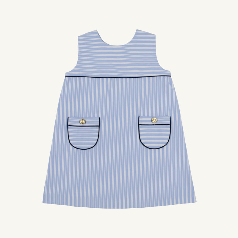 The Jill Jumper - Park City Periwinkle Stripe with Nantucket Navy is a light blue and white sleeveless piece featuring two patch pockets with dark navy trim and a gold button on each pocket.