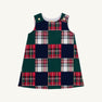 The Juliet Jumper - Mercer Island Madras is a sleeveless toddler dress featuring a checkerboard pattern of solid dark green and red, white, and green plaid squares, with gold-tone button closures on the shoulders.