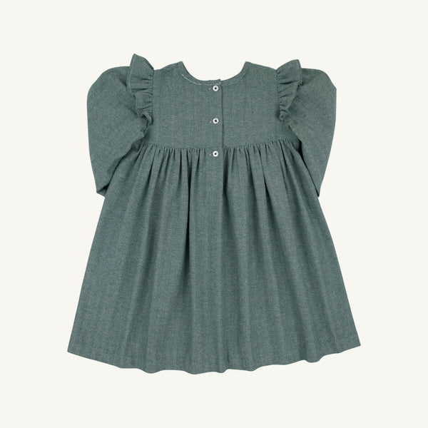 The Long Sleeve Daphne Dress - Grier Green Herringbone by The Beaufort Bonnet Company is shown laid flat on a light background. This dress features a muted green herringbone pattern, puffed long sleeves, ruffle detailing at the shoulders, a gathered skirt, and three buttons down the front.