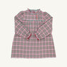 The Beaufort Bonnet Company Long Sleeve Mary Baker Day Dress in Wicker Park Plaid with Richmond Red is a charming toddler girls’ dress featuring a festive red, green, and white plaid pattern. This long-sleeved dress showcases a ruffled collar, ruffled cuffs, and a button-front closure on the bodice. Displayed against a plain off-white background, it’s perfect for your little one as a Christmas or holiday dress.