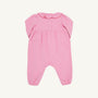 The Long Sleeve Ramona Ruffle Romper - Hamptons Hot Pink with Wreath Embroidery by The Beaufort Bonnet Company is crafted from soft Pima Cotton and features a charming scalloped collar, button details on the chest, and gathered fabric at the waist. Designed for comfort with elastic hems at the legs and wrists, this festive romper makes a perfect holiday outfit and is shown laid flat on a light background.