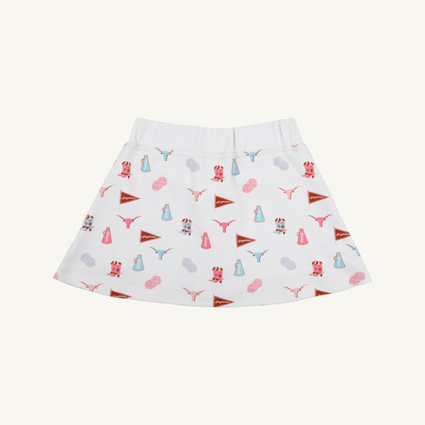 The Texas Searcy Skort - Gone to Texas with Worth Avenue White by The Beaufort Bonnet Company features a playful all-over Gone to Texas print showcasing red and blue pennants, cheerleader megaphones, pom-poms, and cow heads. This vibrant and colorful design pops against the crisp white background.