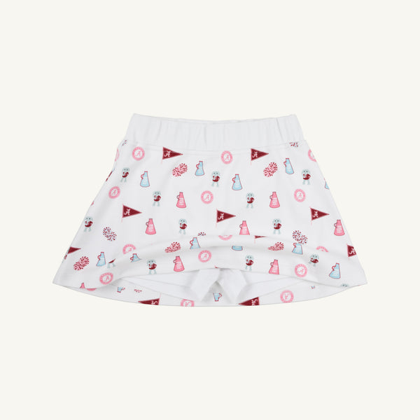 The Alabama Searcy Skort - Sweet Home Honey with Worth Avenue White by The Beaufort Bonnet Company features playful red and pink cheerleader, pom-pom, megaphone, and flag patterns. Made from soft Pima Cotton Knit, this skort offers a wide elastic waistband and attached shorts for added comfort.