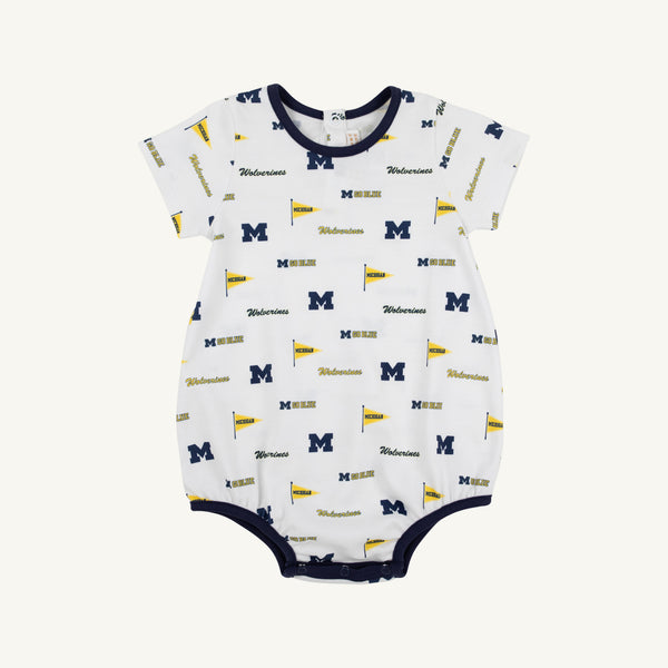 Dress your little one for game day in the Michigan Short Sleeve Patton Play Bubble - Bold in Blue with Michigan Blue by The Beaufort Bonnet Company. This adorable white baby romper is made from soft Pima Cotton Knit and features short sleeves, navy trim on the collar, sleeves, and leg openings, and a playful design with repeating University of Michigan logos, blue “M” letters, yellow flags, and “Wolverines” text—making it the perfect outfit for your future fan!.