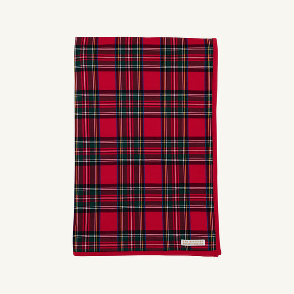 A folded Silent Night Throw - Society Prep Plaid blanket in a red, green, and white plaid pattern with a solid red border.