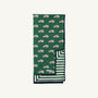 The Beaufort Bonnet Company’s Silent Night Throw in the Windsor Wagon (Grier Green) design features a cheerful pattern of red and white cars on top, with Palmetto Pearl & Grier Green stripes on the underside, both visible in the image.