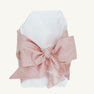 Newborn wrapped in a white Bow Swaddle ® - Southern Blush Silk, featuring a large, dusty pink bow, perfect for baby keepsake pictures.