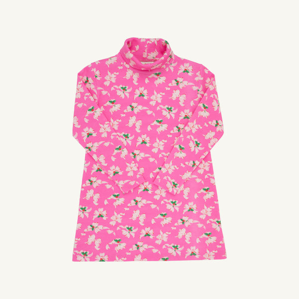 Tatum’s Turtleneck Dress - Bows of Holly by The Beaufort Bonnet Company is a long-sleeved pink turtleneck dress made from soft Pima cotton, adorned with an all-over pattern of white and light pink flowers with green leaves. This holiday dress is shown laid flat against a white background.