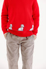 Red long-sleeved Isaac’s Intarsia Sweater - Richmond Red with Grantley Gray and Dogs featuring a row of three small puppy motifs along the hem, worn with gray pants.
