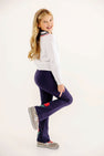 A girl stands on one leg wearing a Vivie June V-Neck Sweater - Worth Avenue White with Richmond Red & Nantucket Navy & Flowers and navy pants featuring embroidered flowers.