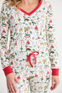 A person wearing the Coastal Living Lounge Set - 12 Days of Christmas with Richmond Red by The Beaufort Bonnet Company, featuring festive Twelve Days of Christmas illustrations on soft Pima Cotton fabric, and finished with red trim on the collar, cuffs, and drawstring.