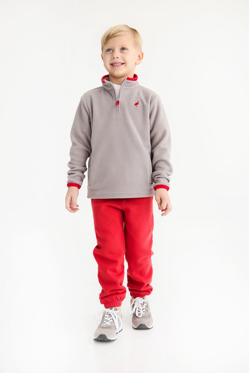A young boy wears a cozy grey quarter-zip fleece pullover with red trim and matching Gates Sweeney Sweatpants - Richmond Red with Nantucket Navy Stork.