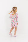 A young girl wearing a Long Sleeve Polly Play Dress - Christmas Coloring Contest, a long-sleeve Pima cotton dress printed with festive snow globes and trees.