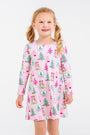 A young girl wears a long-sleeved, pink Long Sleeve Polly Play Dress - Christmas Coloring Contest in Pima cotton, printed with colorful trees and snow globes.